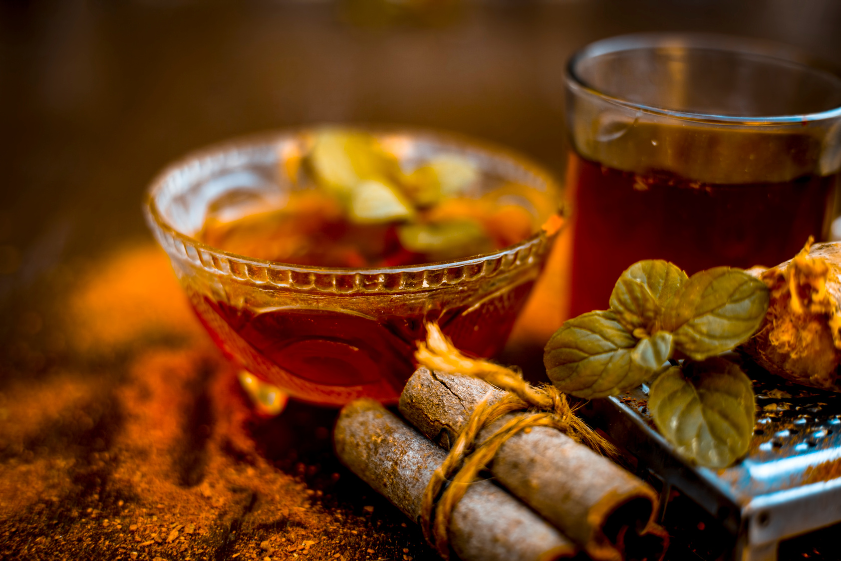 Close up of Ayurvedic home remedy for common cold: Fresh organic ginger ( grated) , warm water, cinnamon stick, honey, and lemon juice.